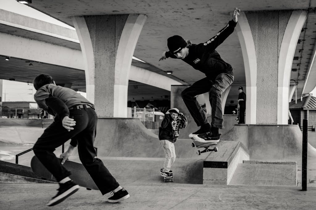 Monochrome Photo of Men Skateboarding